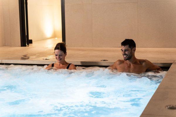 Pareja disfrutando de una piscina de hidromasaje en el spa Foresta Wellness de ARIMA Hotel & Spa.